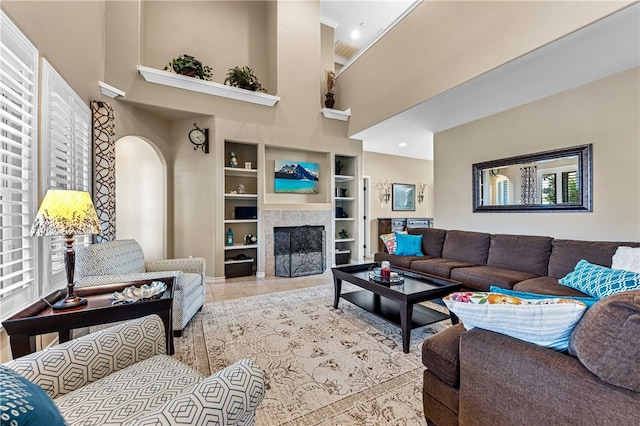 tiled living room with built in shelves and a towering ceiling