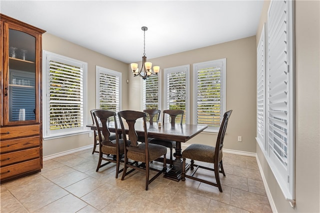 dining area with light tile patterned floors and an inviting chandelier