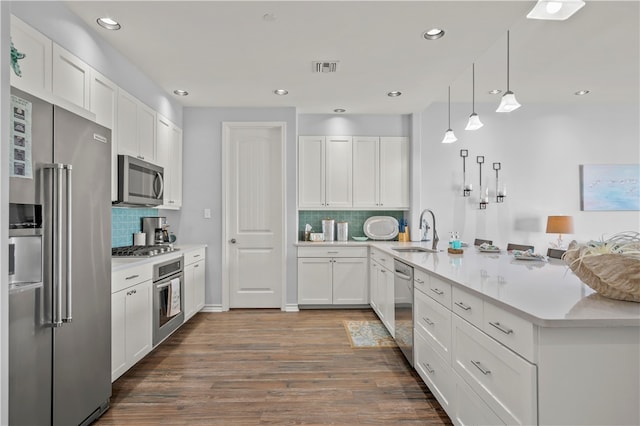 kitchen featuring sink, dark hardwood / wood-style floors, decorative backsplash, white cabinetry, and stainless steel appliances