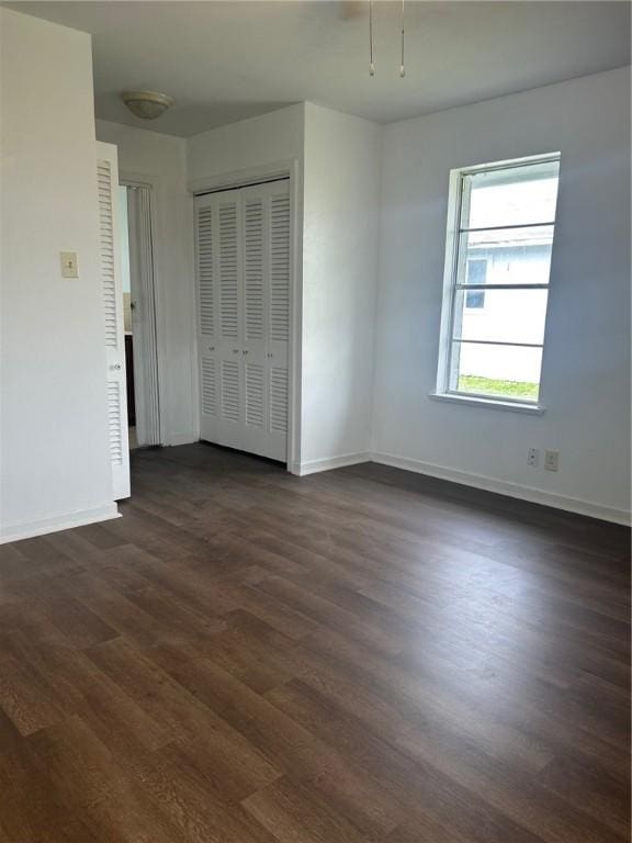 unfurnished bedroom featuring dark hardwood / wood-style floors and a closet