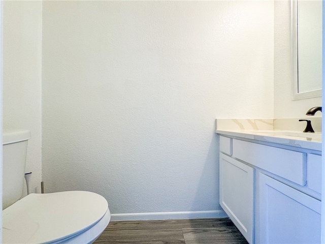 bathroom featuring hardwood / wood-style flooring, vanity, and toilet