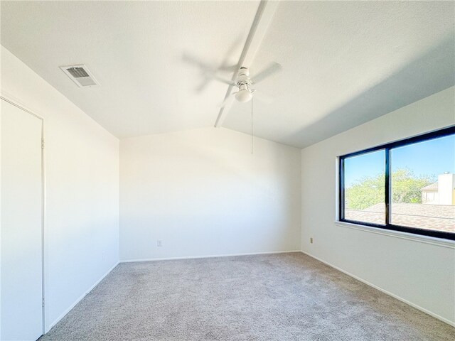 carpeted spare room with ceiling fan and vaulted ceiling