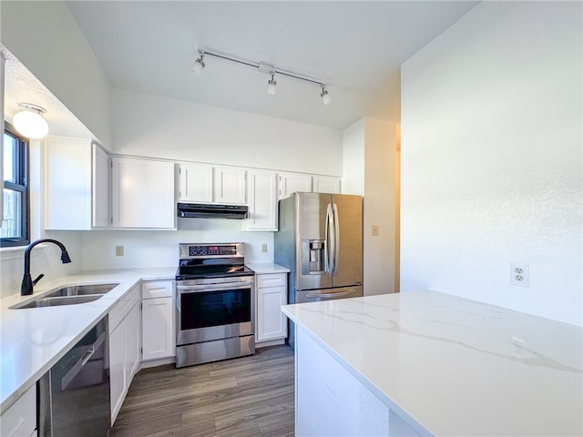 kitchen featuring stainless steel appliances, white cabinets, hardwood / wood-style floors, sink, and rail lighting