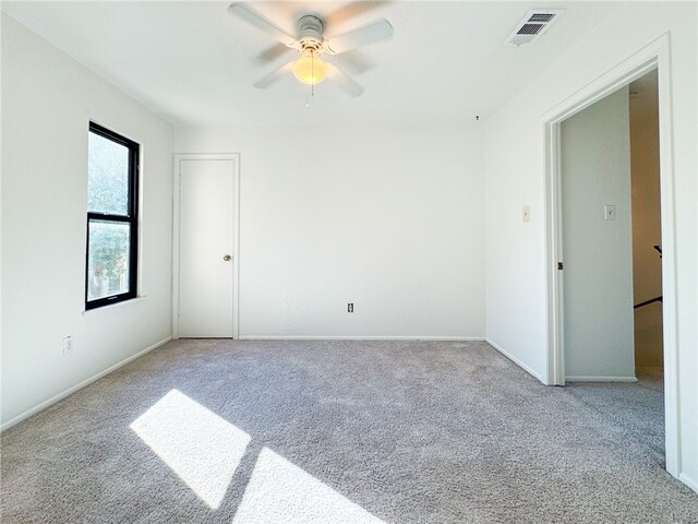 carpeted spare room featuring ceiling fan