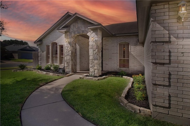 7002 Madiera Dr, Corpus Christi, TX 78414 - view of front of home with brick siding, a front yard, and roof with shingles
