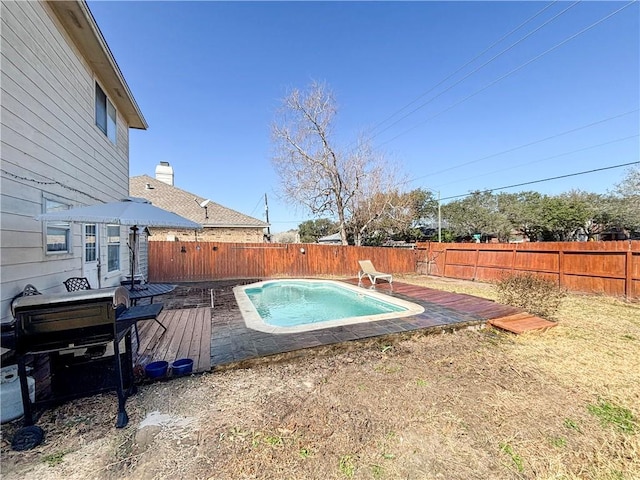 view of swimming pool featuring a fenced in pool, a wooden deck, and a fenced backyard