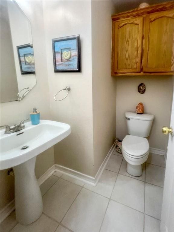 bathroom featuring tile patterned floors, toilet, and baseboards