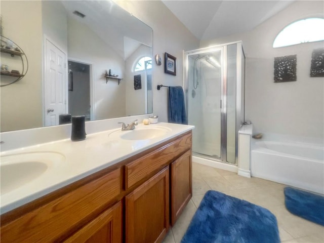 bathroom featuring a garden tub, a sink, a shower stall, double vanity, and lofted ceiling