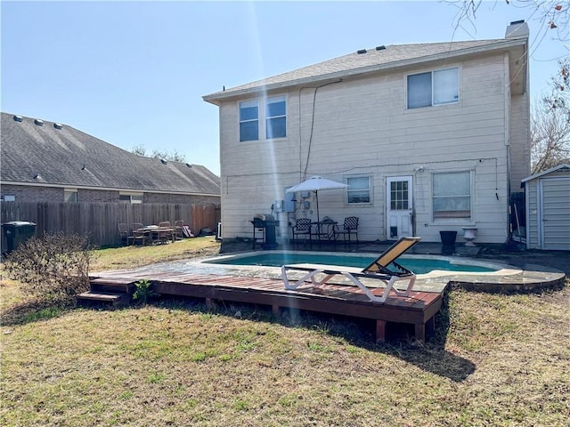 back of property featuring a lawn, a wooden deck, and fence