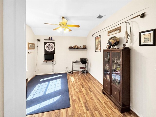 living area featuring visible vents, ceiling fan, baseboards, and light wood-style floors