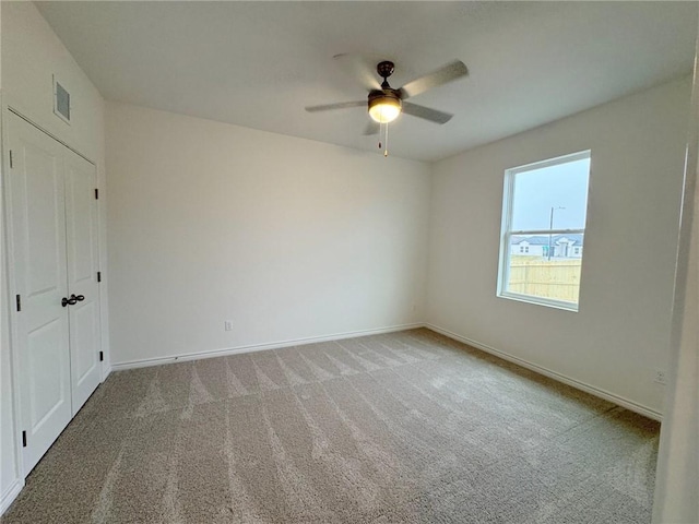 carpeted empty room featuring ceiling fan