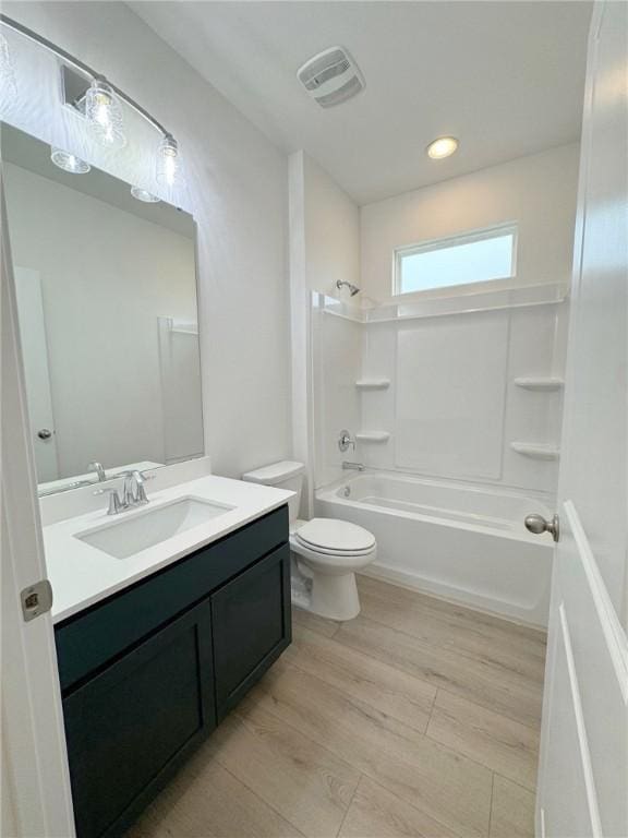 full bathroom featuring vanity, hardwood / wood-style floors, shower / bathing tub combination, and toilet