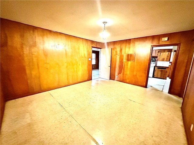 unfurnished room featuring wood walls