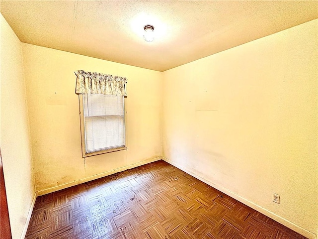 unfurnished room with parquet floors and a textured ceiling