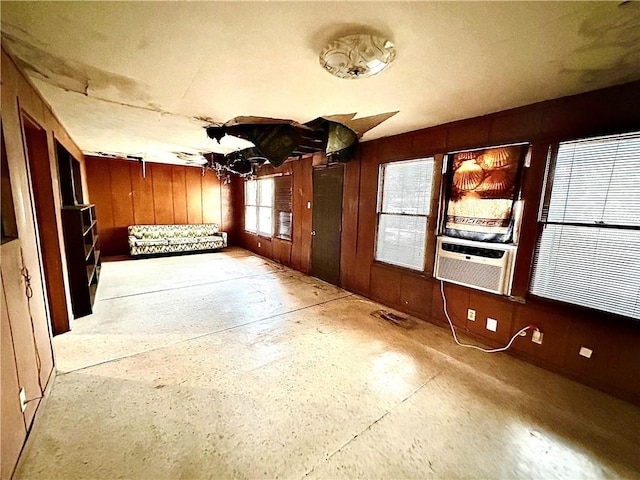 interior space with wood walls, cooling unit, and an inviting chandelier