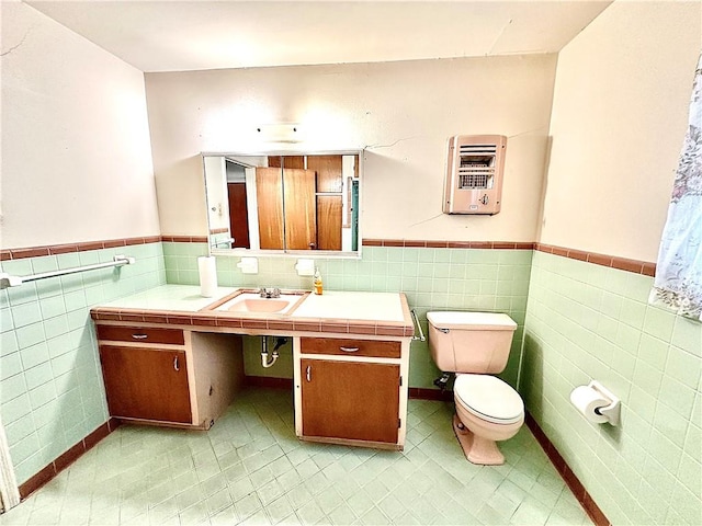 bathroom with tile patterned flooring, heating unit, toilet, and tile walls