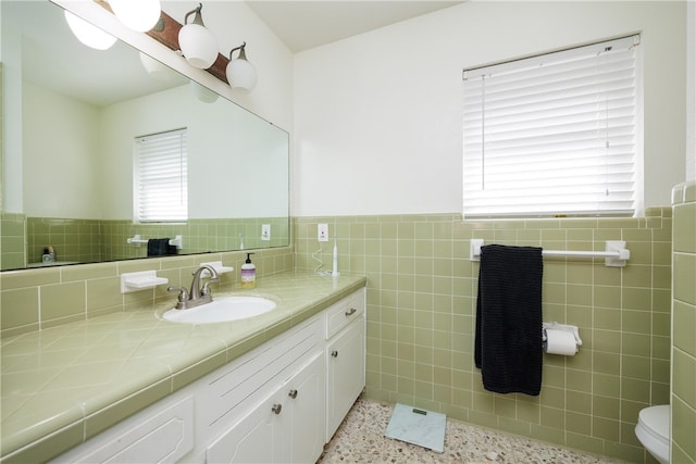 bathroom with vanity, plenty of natural light, and tile walls