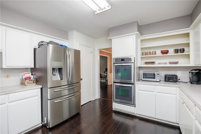 kitchen with white cabinets, dark hardwood / wood-style flooring, and appliances with stainless steel finishes