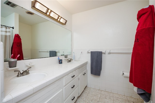 bathroom featuring vanity and tile walls