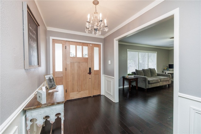 entrance foyer featuring dark wood-type flooring, a notable chandelier, and ornamental molding