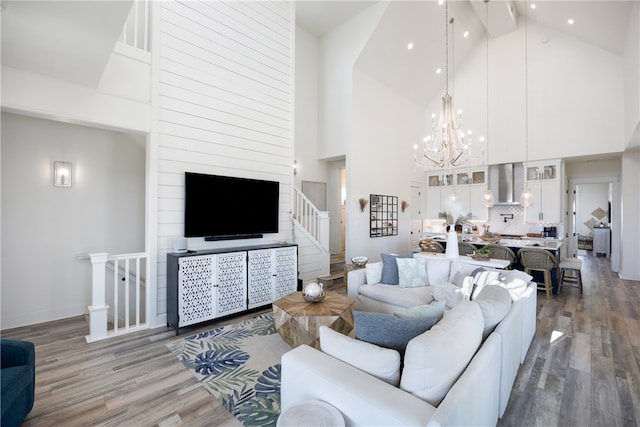 living room featuring hardwood / wood-style floors, a notable chandelier, and high vaulted ceiling