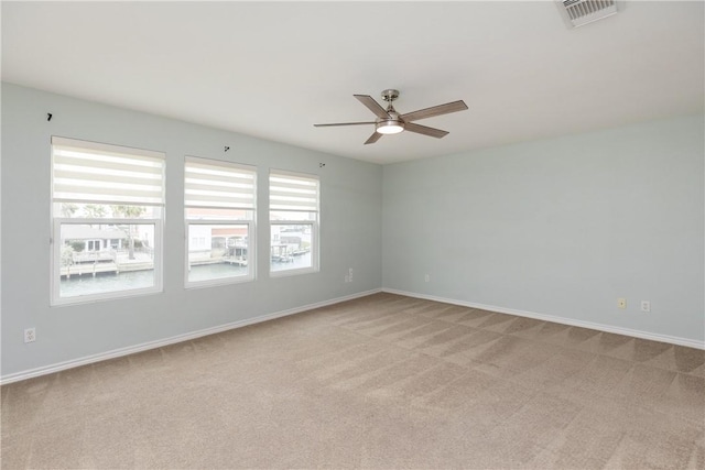 carpeted spare room featuring ceiling fan