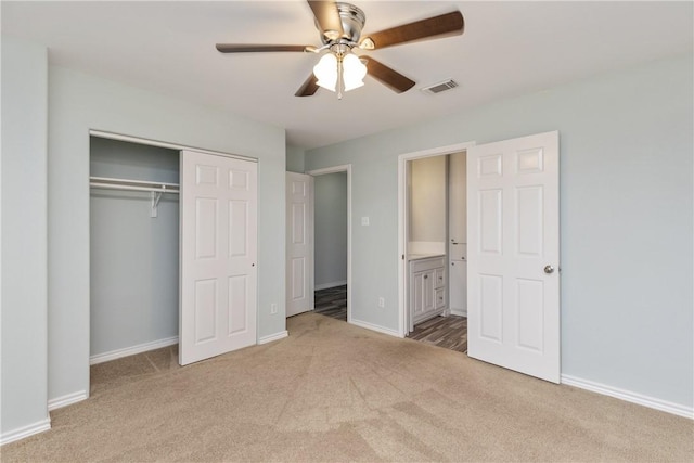 unfurnished bedroom with connected bathroom, ceiling fan, a closet, and light carpet