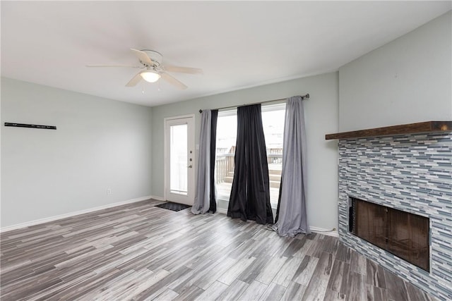 unfurnished living room featuring a fireplace, light hardwood / wood-style flooring, and ceiling fan