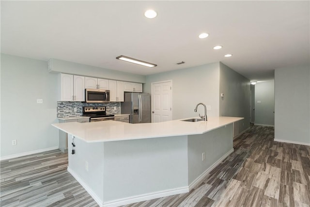 kitchen with sink, stainless steel appliances, tasteful backsplash, a spacious island, and white cabinets