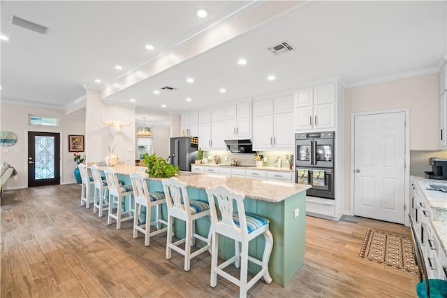 2110 Harbor Ct, Rockport, TX 78382 - kitchen featuring black appliances, crown molding, decorative backsplash, a kitchen bar, and white cabinetry