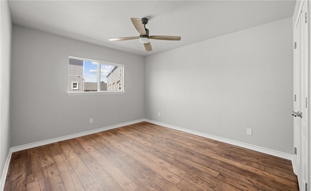 spare room with ceiling fan, baseboards, and hardwood / wood-style flooring