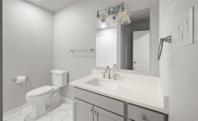 bathroom with baseboards, vanity, toilet, and tile patterned floors