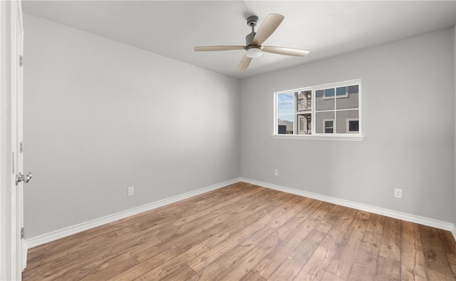 empty room featuring light wood-type flooring, ceiling fan, and baseboards