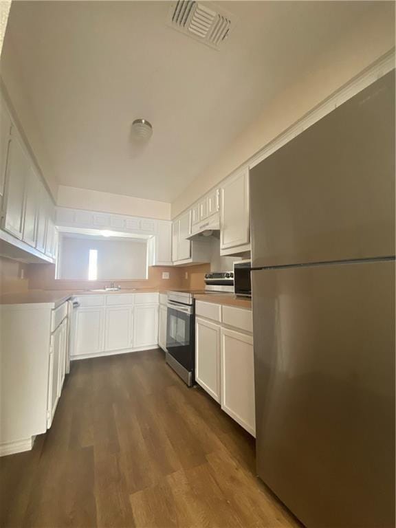 kitchen featuring dark wood finished floors, white cabinetry, visible vents, and appliances with stainless steel finishes