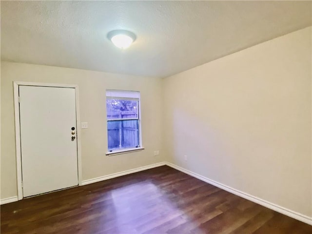 entrance foyer with baseboards, a textured ceiling, and dark wood-style floors