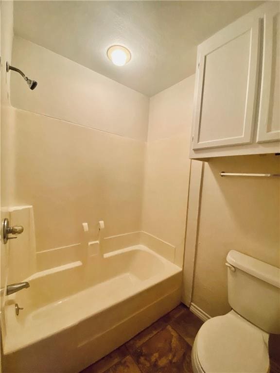 bathroom with toilet, baseboards, and shower / washtub combination