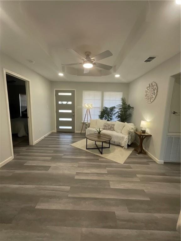 living area with wood finished floors, visible vents, and baseboards