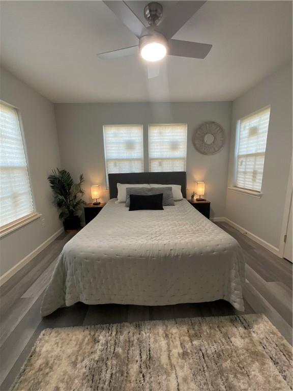 bedroom featuring dark wood-type flooring, ceiling fan, and baseboards