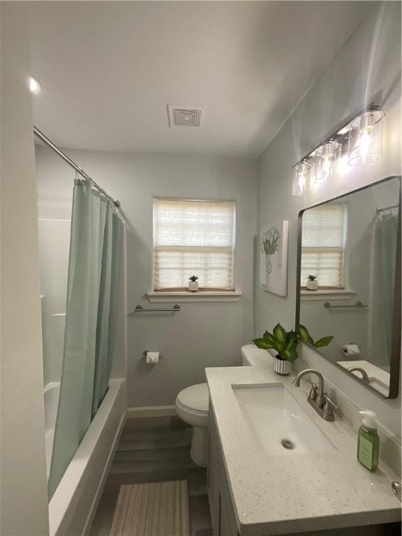 bathroom with visible vents, toilet, shower / bath combo, vanity, and baseboards