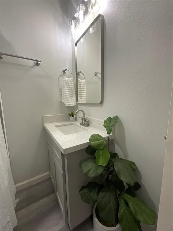 bathroom featuring baseboards, wood finished floors, and vanity