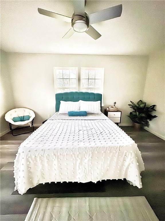 bedroom featuring ceiling fan, wood finished floors, and baseboards