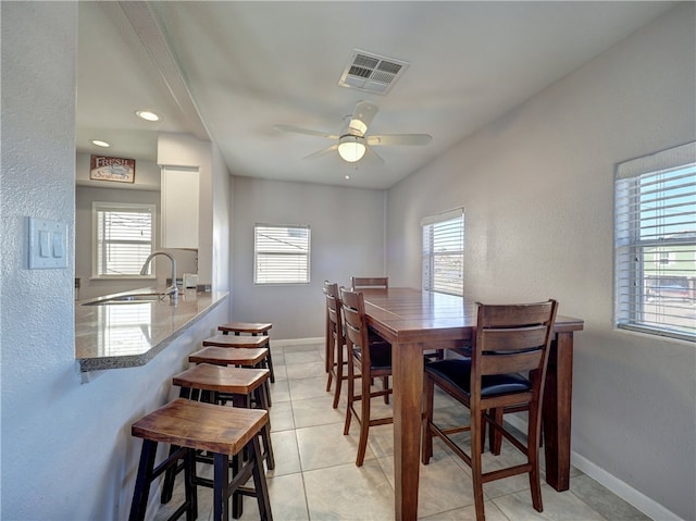 dining room with ceiling fan, sink, light tile patterned floors, and a healthy amount of sunlight