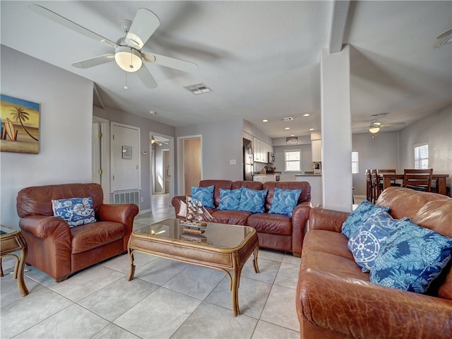 tiled living room with ceiling fan and a wealth of natural light