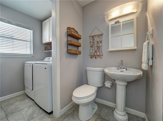 bathroom with tile patterned floors, toilet, and washing machine and clothes dryer