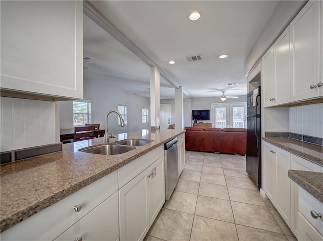 kitchen featuring french doors, black fridge, stainless steel dishwasher, sink, and white cabinetry