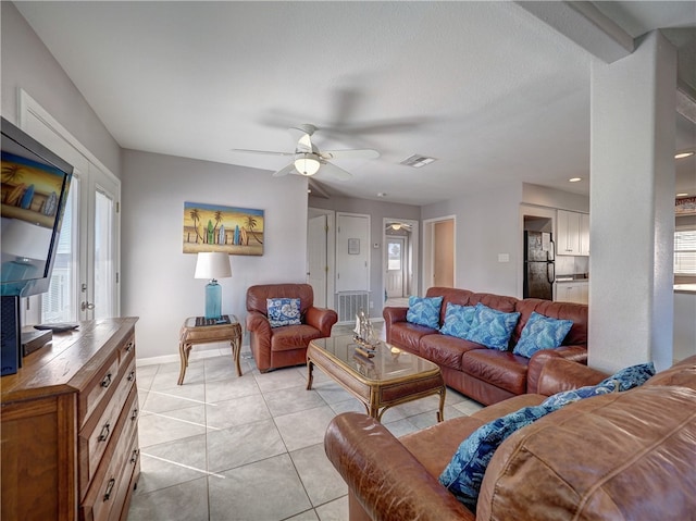 living room featuring ceiling fan, light tile patterned floors, and a textured ceiling