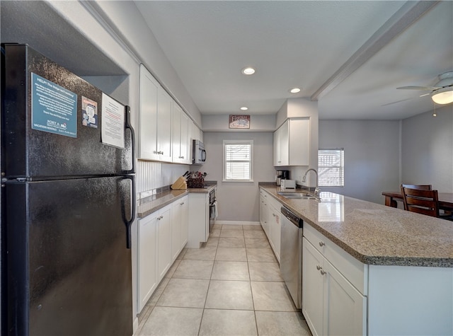 kitchen featuring sink, ceiling fan, light tile patterned floors, white cabinetry, and stainless steel appliances