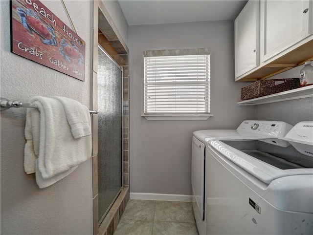 washroom with cabinets, light tile patterned floors, and separate washer and dryer