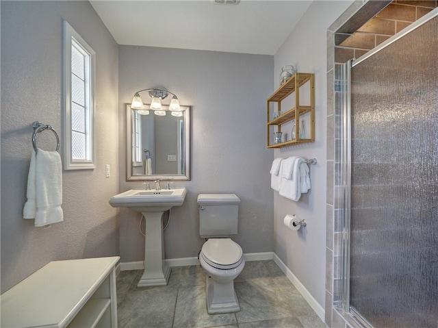 bathroom featuring tile patterned floors, toilet, a shower with shower door, and sink