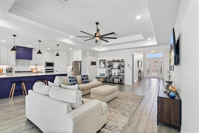 7910 Parham Dr, Corpus Christi, TX 78414 - living room with a tray ceiling, recessed lighting, a ceiling fan, and light wood-style floors